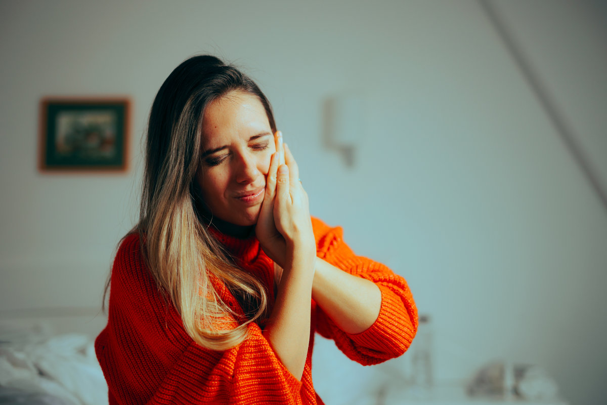 Woman holding her jaw in pain